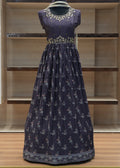Navy blue dress with white floral pattern on a mannequin against a wooden panel background