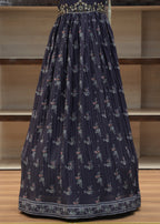 Navy blue pleated skirt with floral pattern on a wooden chair.