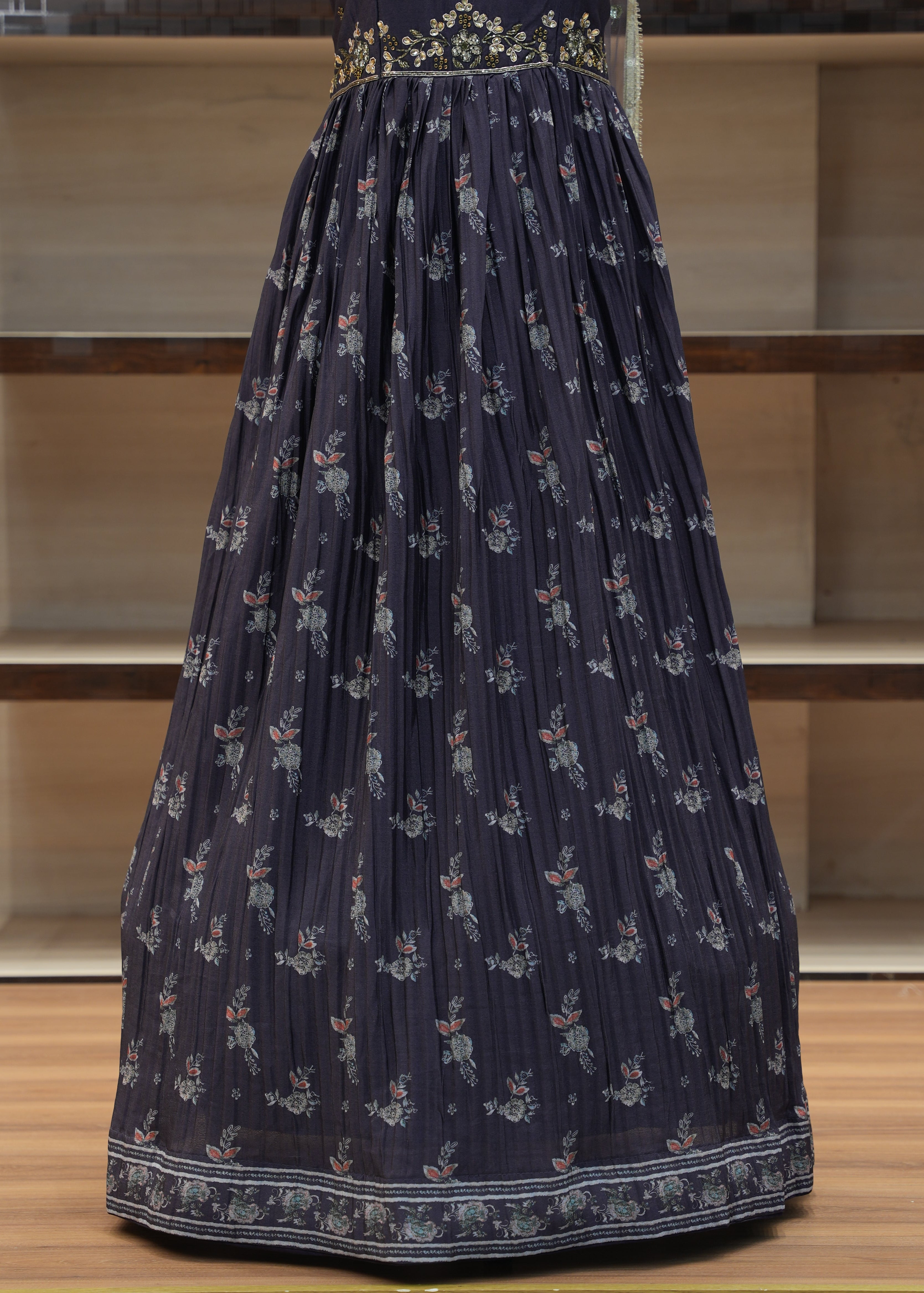Navy blue pleated skirt with floral pattern on a wooden chair.