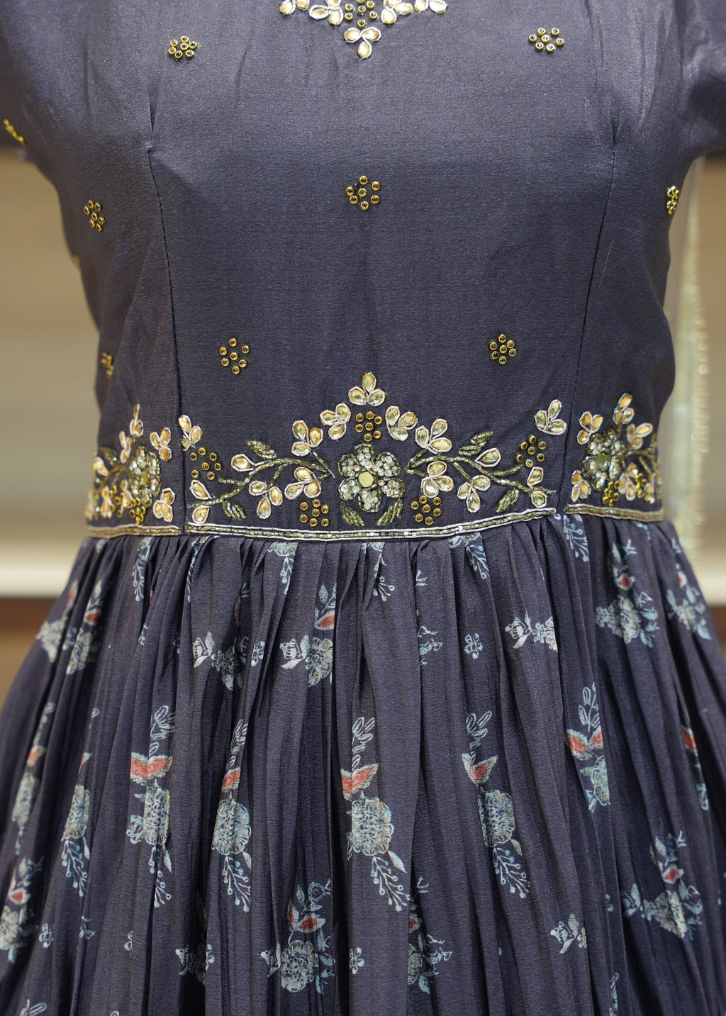 Navy blue dress with floral patterns and gold embroidery on a blurred background