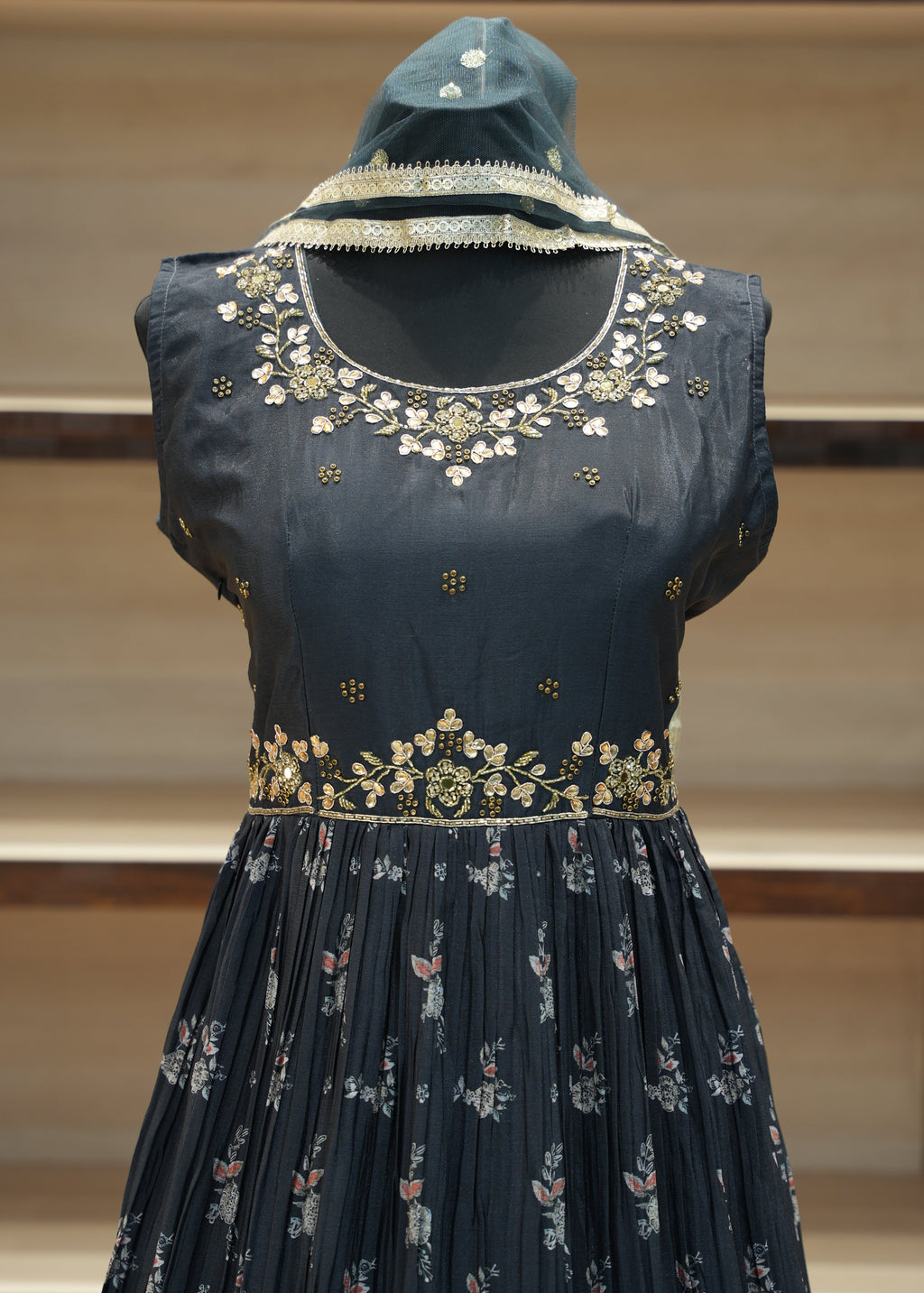 Black embroidered blouse on a mannequin against a neutral background
