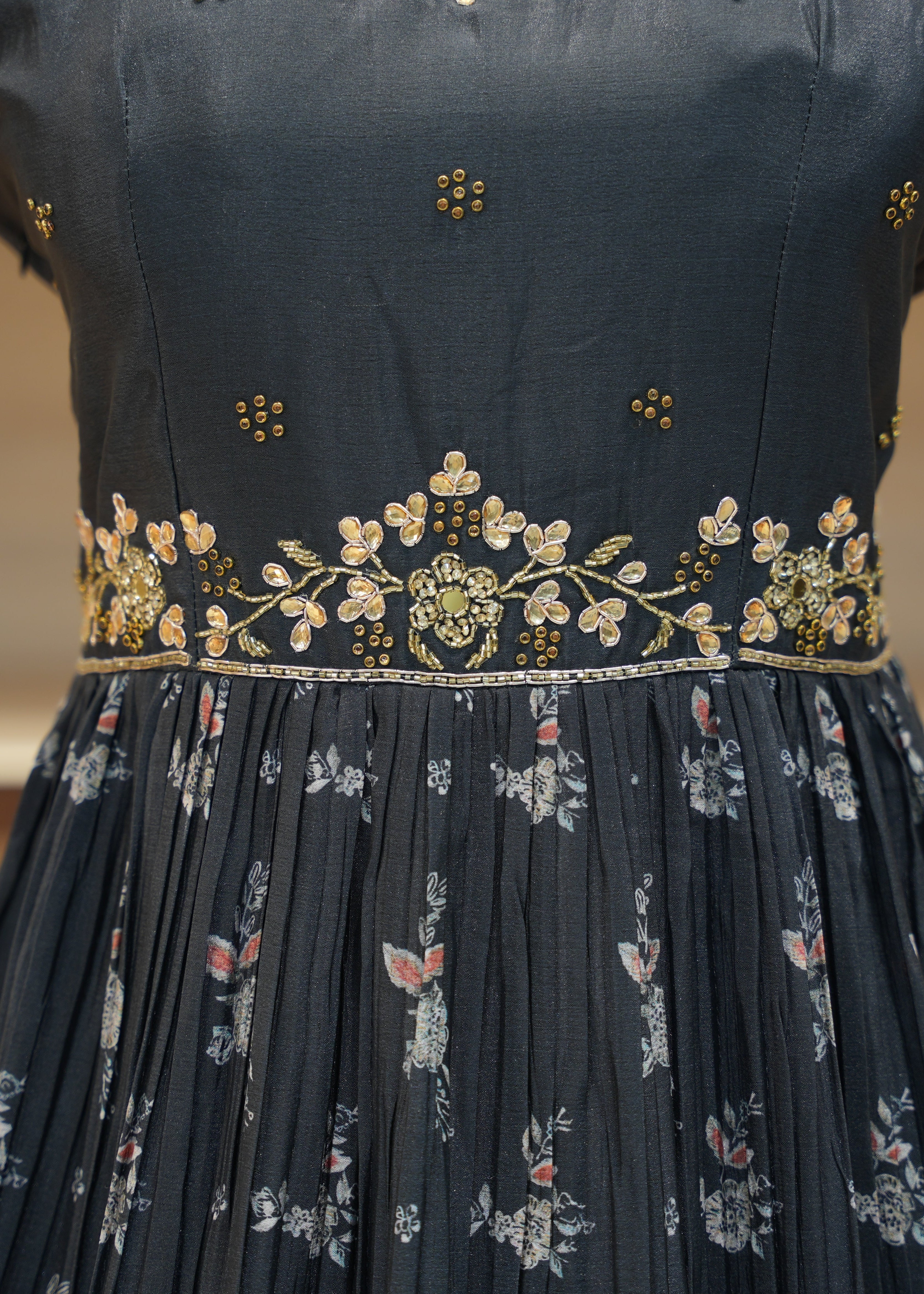 Navy blue dress with floral patterns and gold embroidery on a blurred background