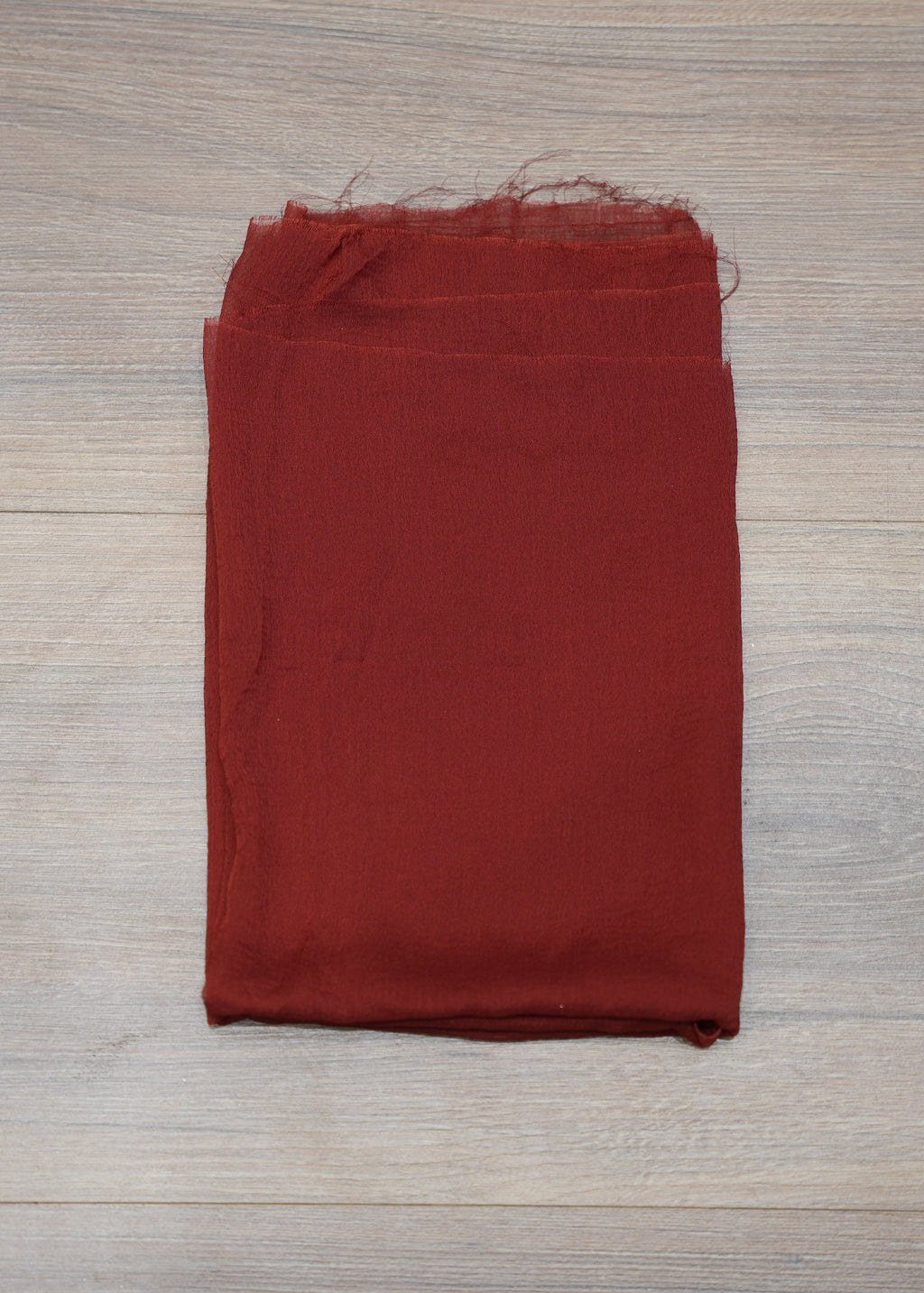 Folded red fabric on a wooden surface