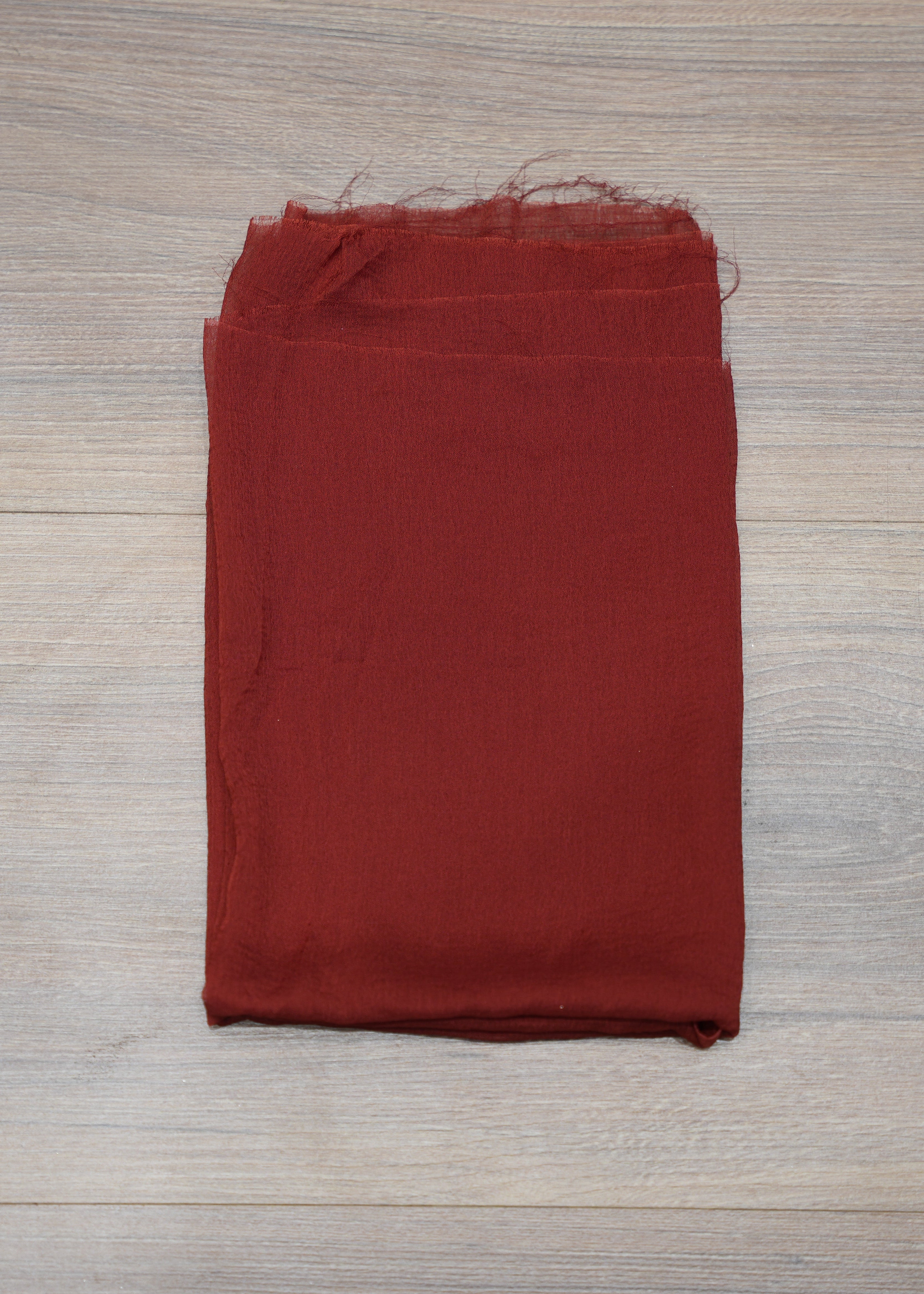 Folded red fabric on a wooden surface