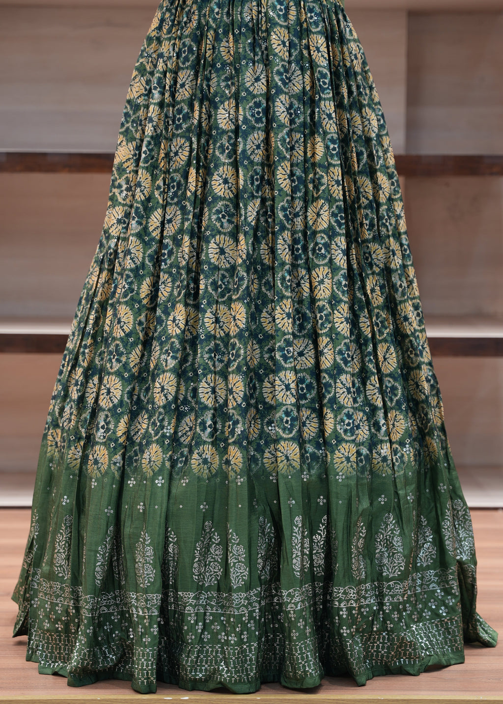 Stack of green patterned fabric on a wooden surface
