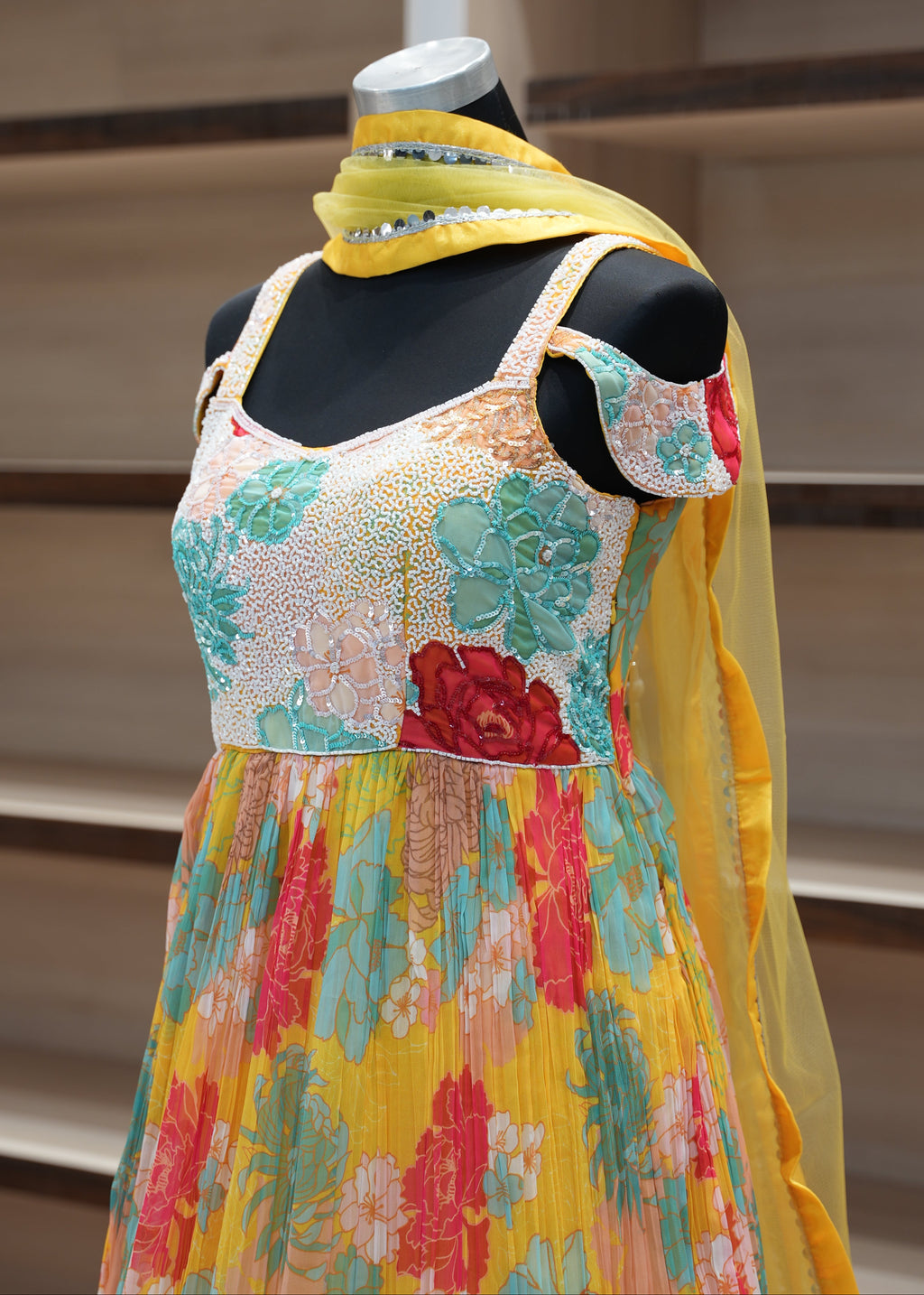 Colorful floral dress on a mannequin against a neutral background