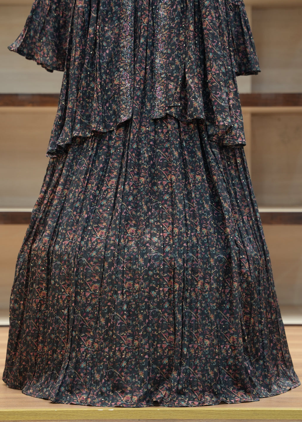 Dark patterned pleated skirt on a mannequin against a neutral background