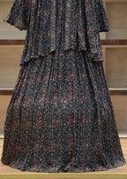 Dark patterned pleated skirt on a mannequin against a neutral background