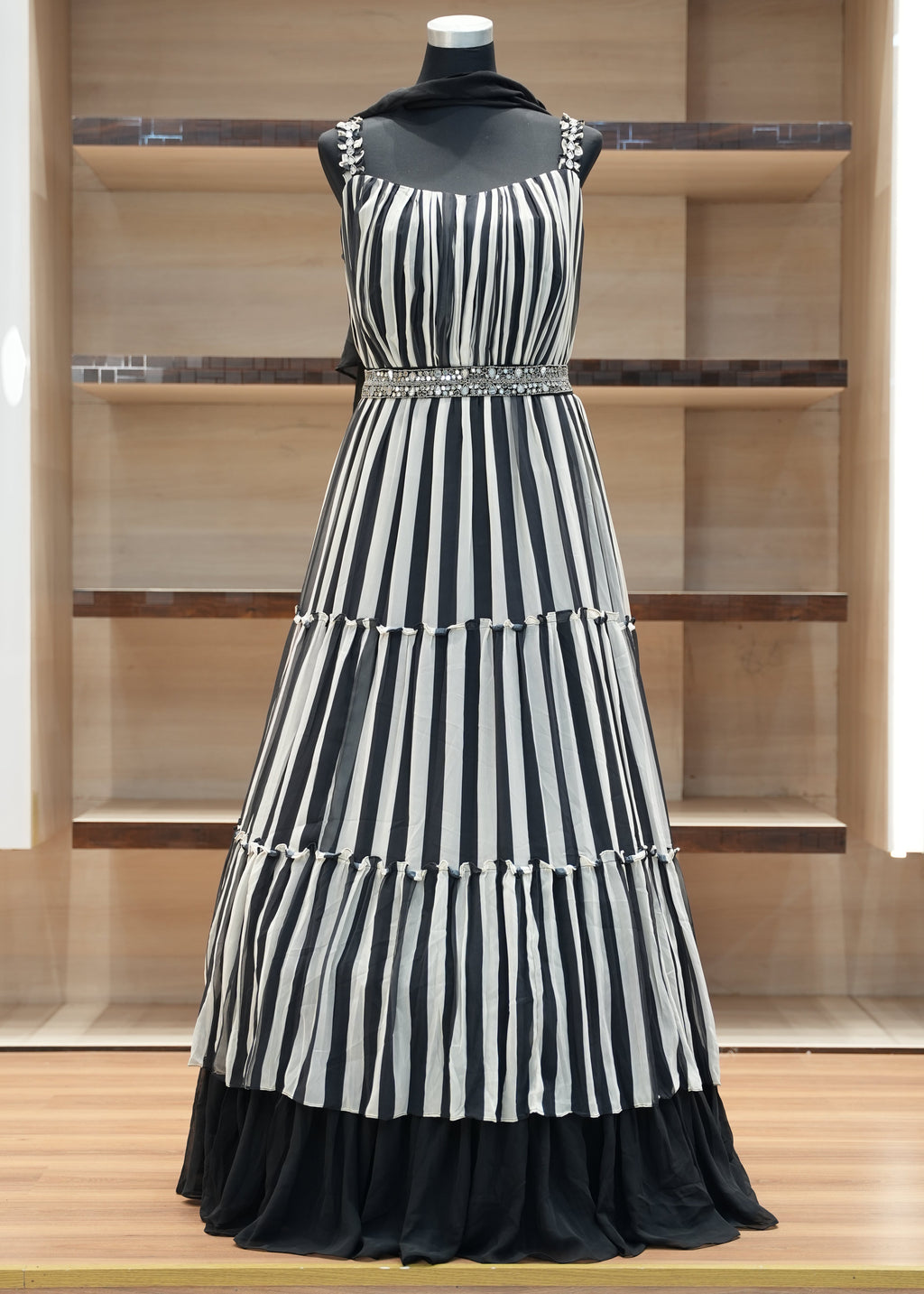 Black and white striped dress on a mannequin against a wooden panel background