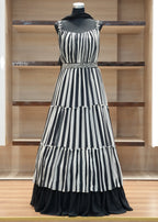 Black and white striped dress on a mannequin against a wooden panel background