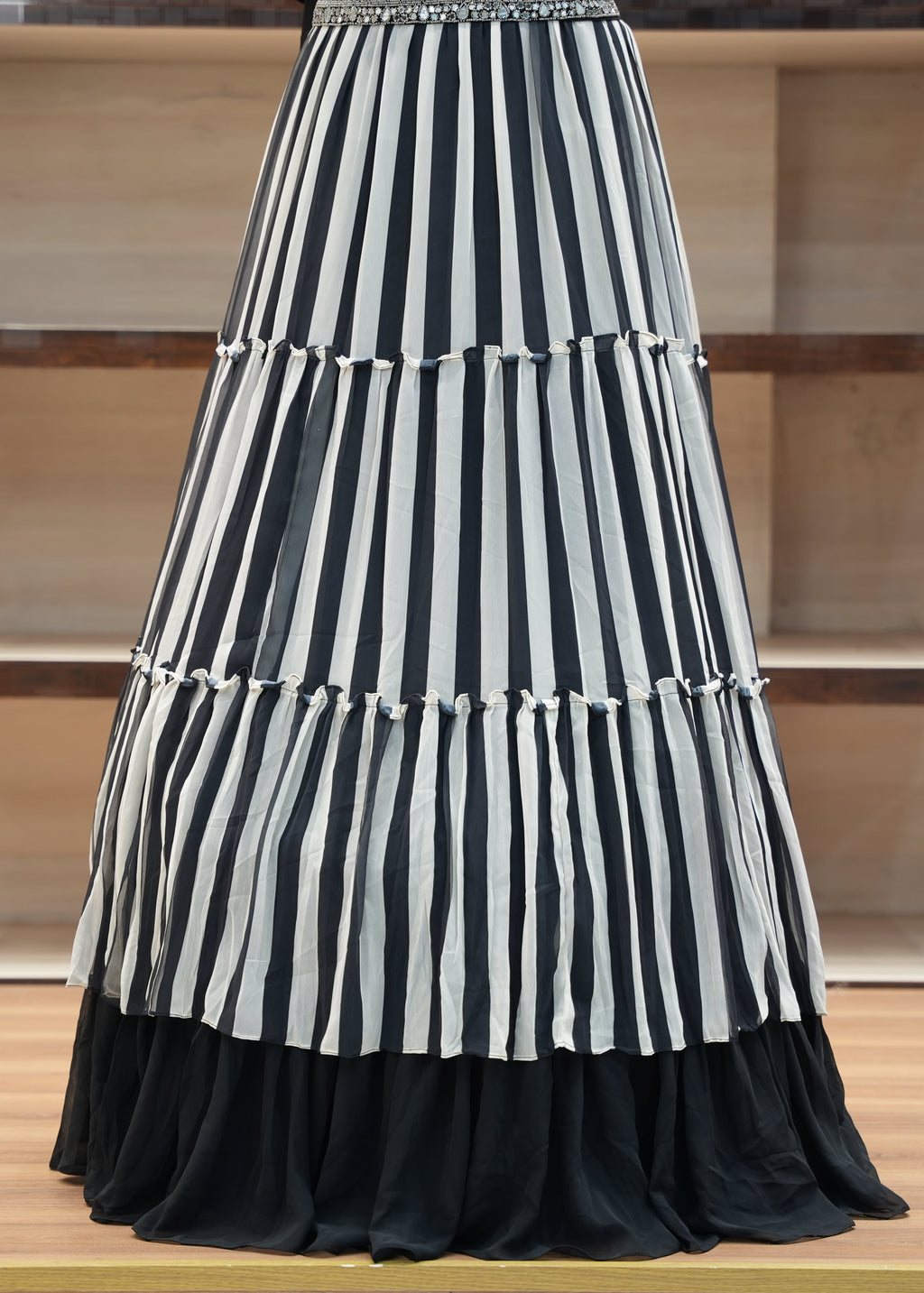 Black and white striped skirt on a wooden floor with a neutral background