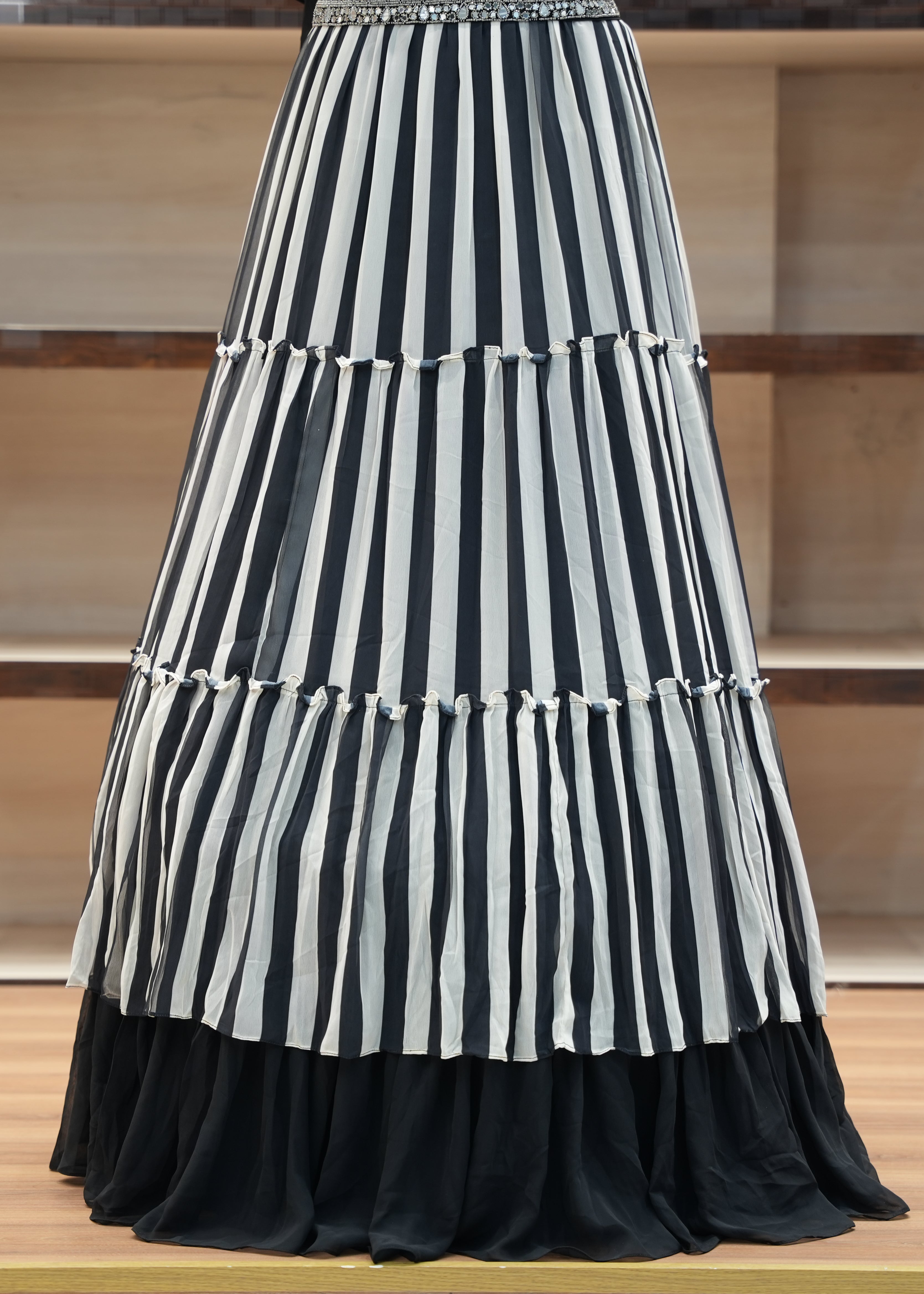 Black and white striped skirt on a wooden floor with a neutral background