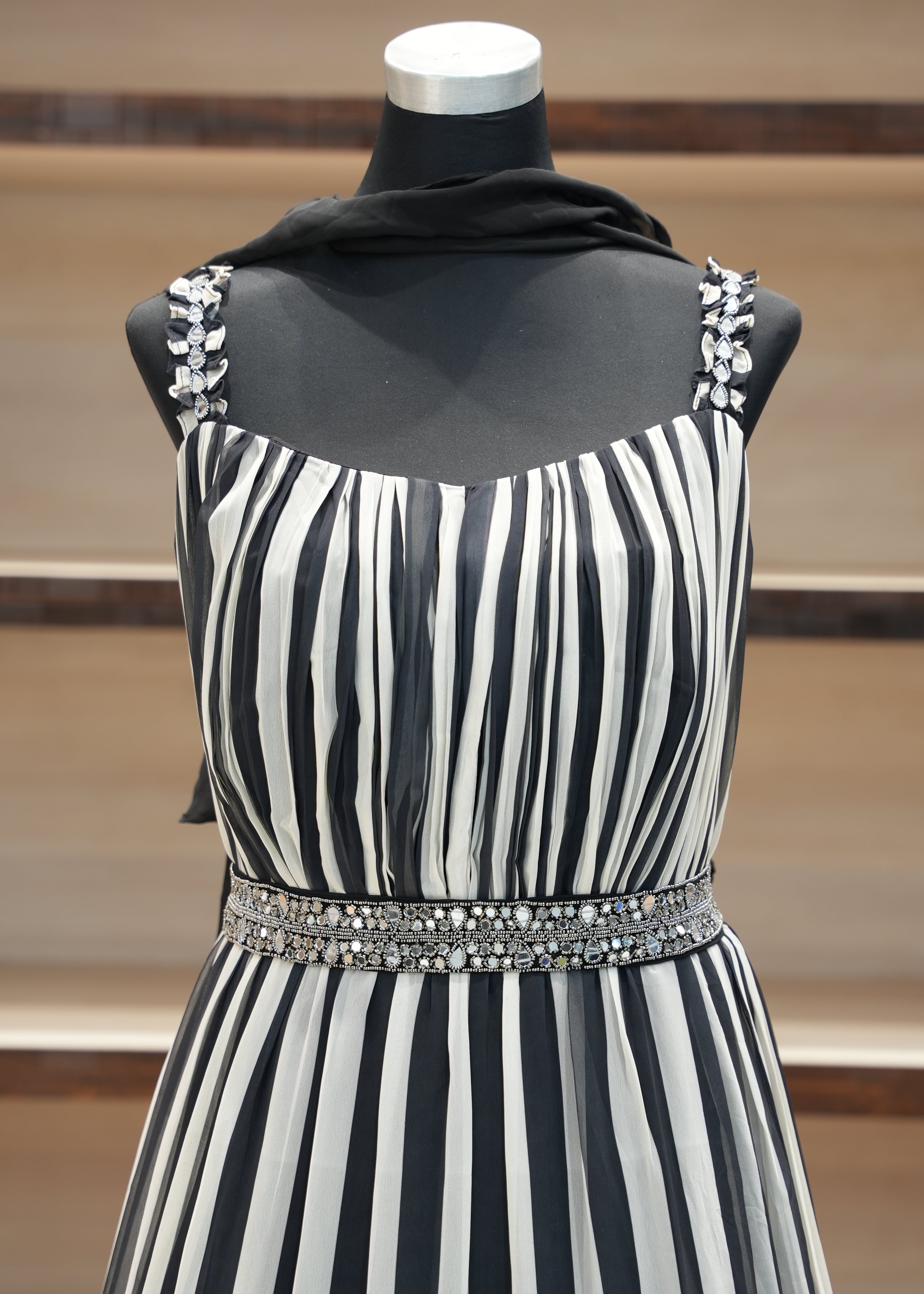 Black and white striped dress with embellishments on a mannequin against a neutral background