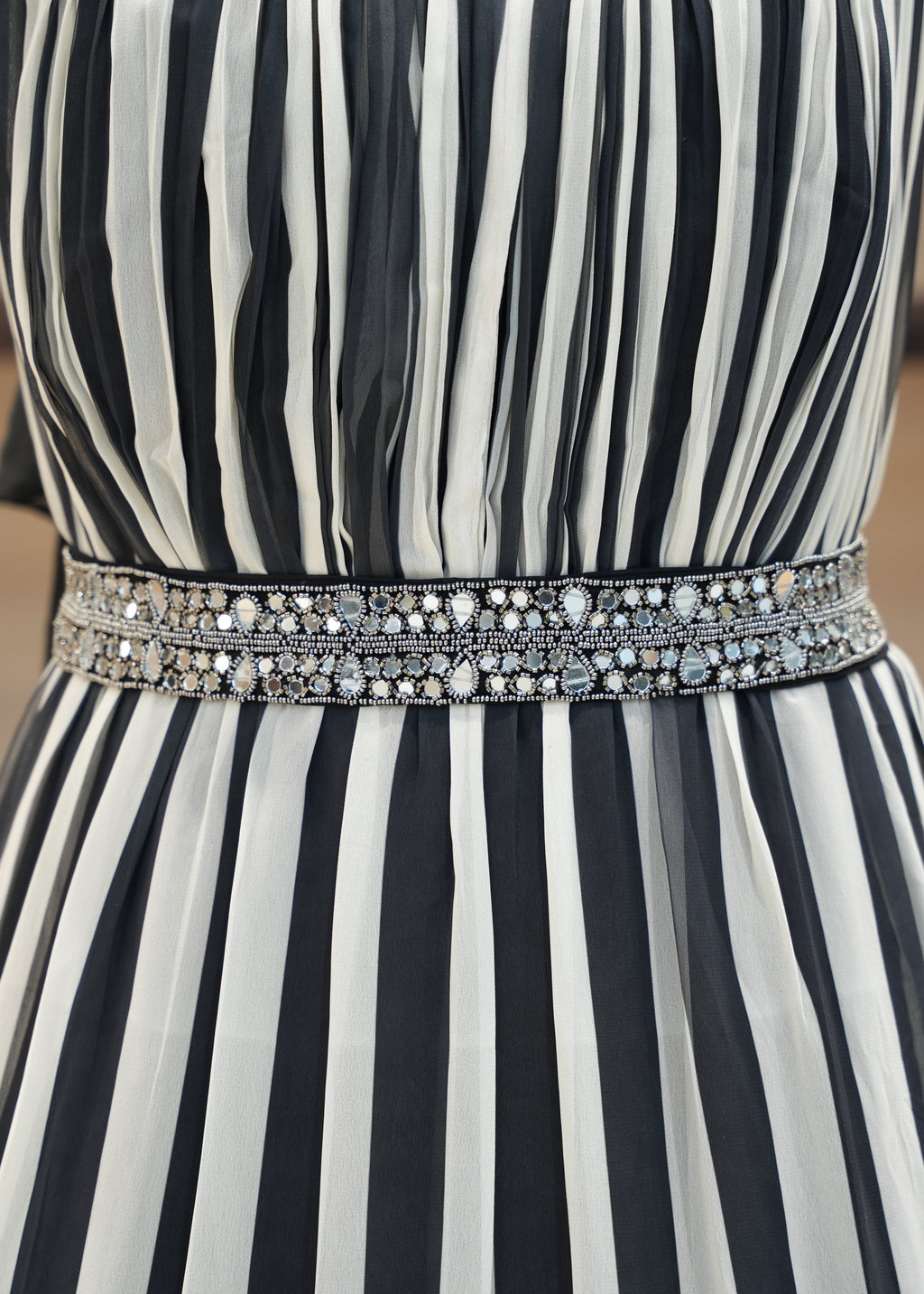 Black and white striped dress with a decorative belt on a blurred background
