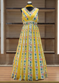 Yellow floral dress on a mannequin against a wooden background