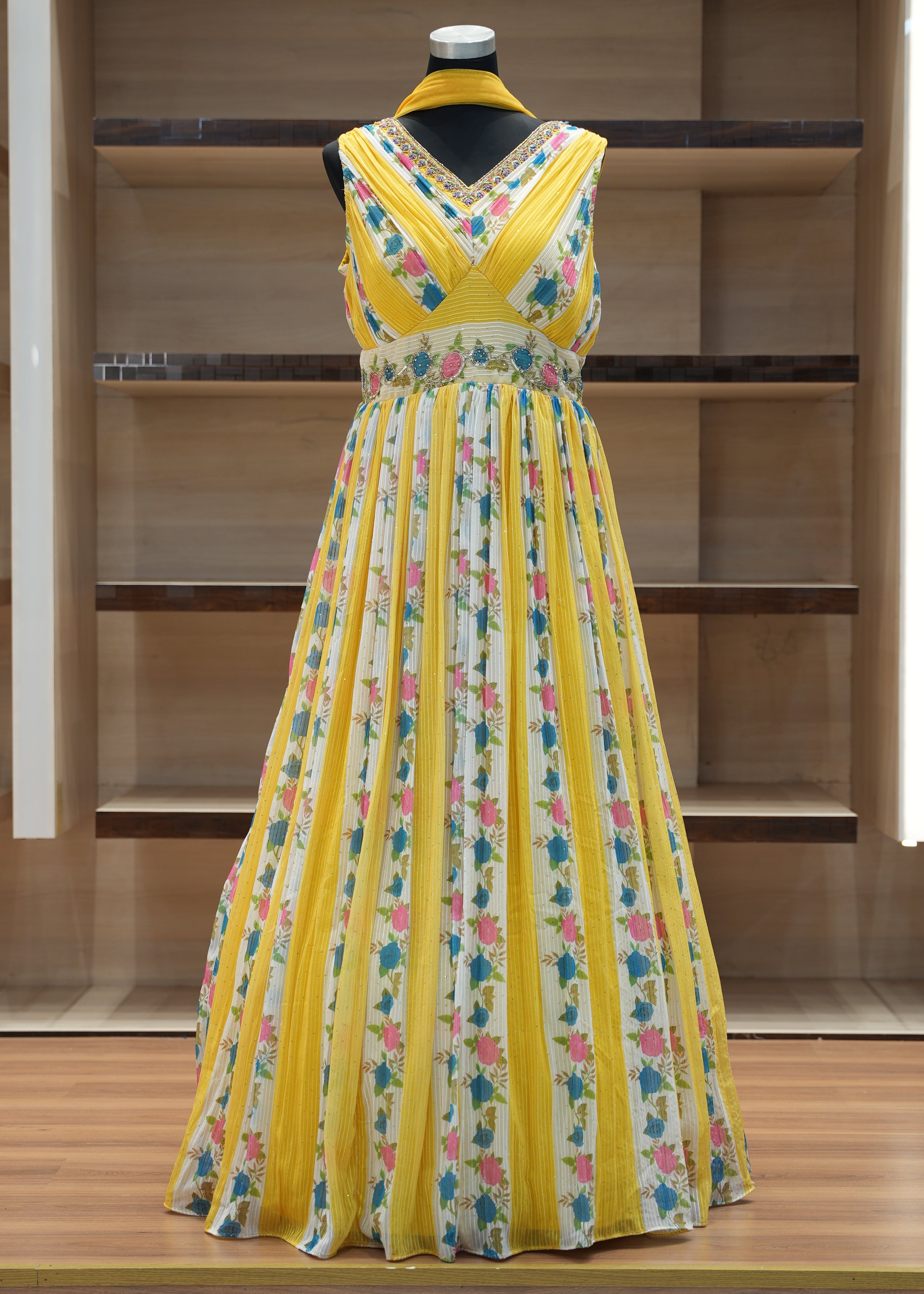 Yellow floral dress on a mannequin against a wooden background