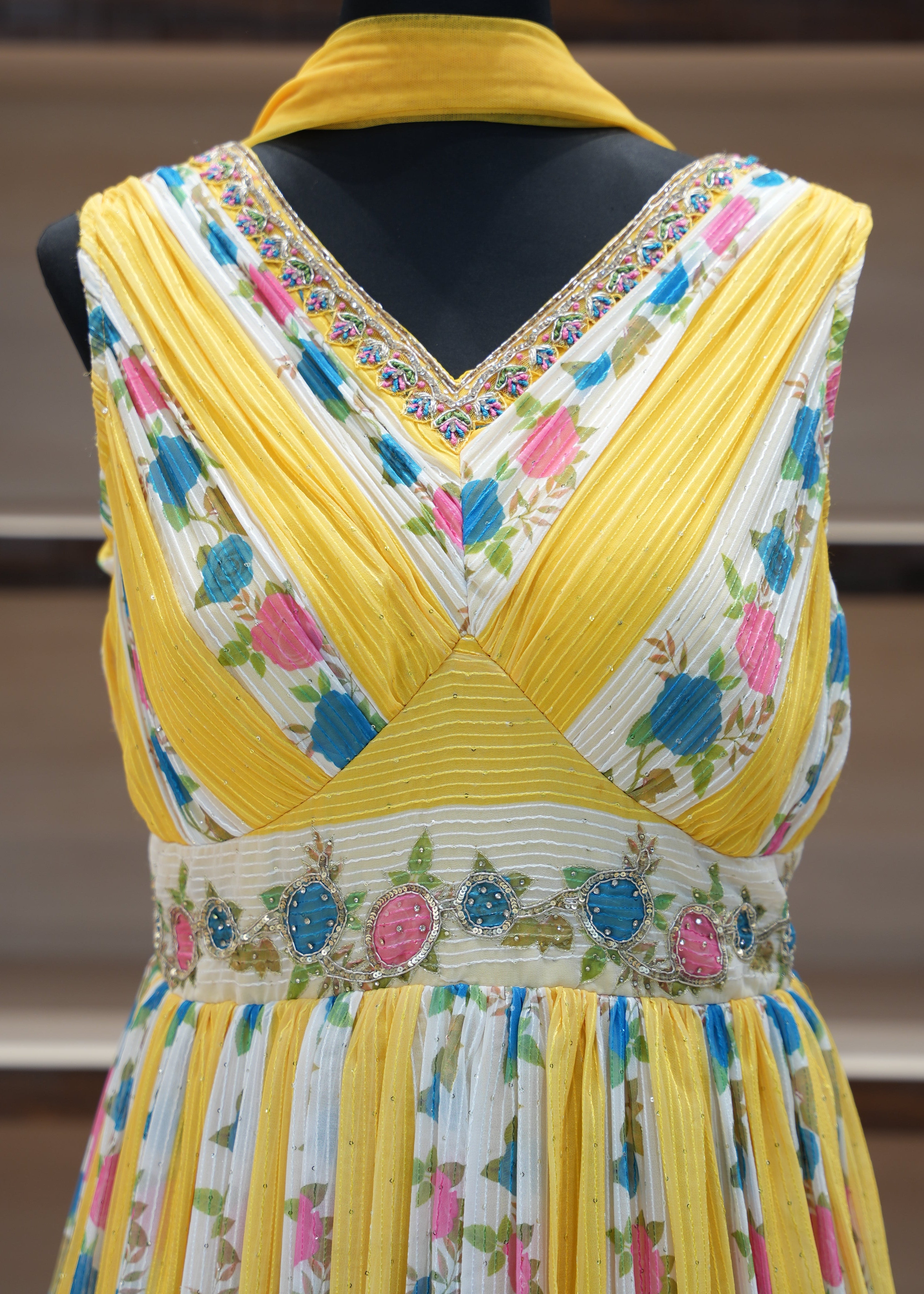 Colorful dress with floral patterns on a mannequin against a blurred background