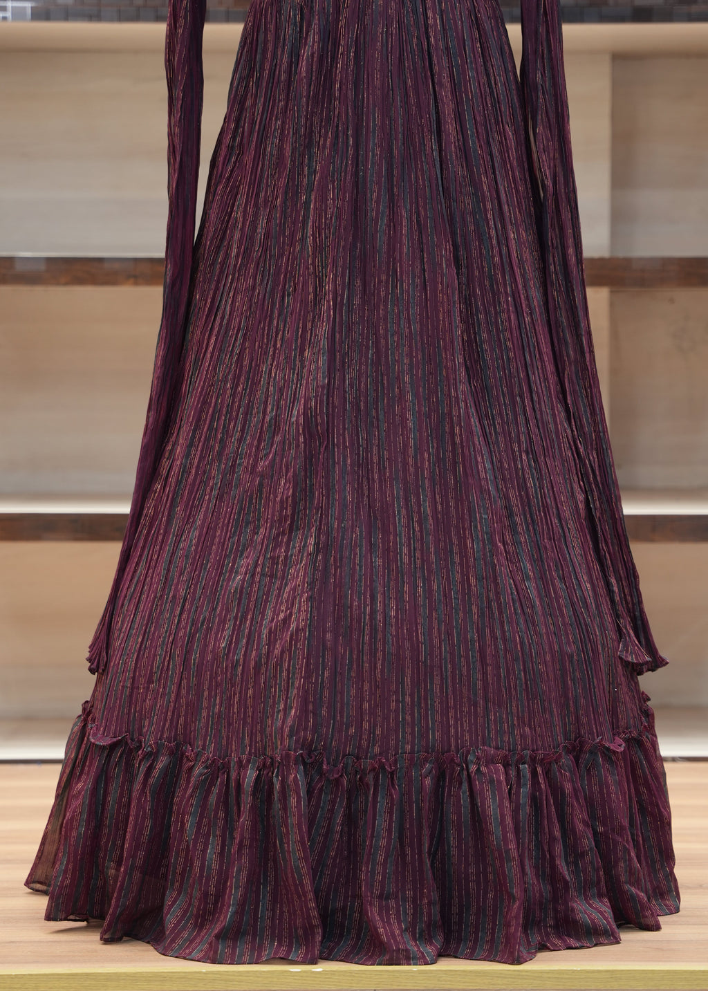 Purple pleated fabric on a wooden shelf with a neutral background