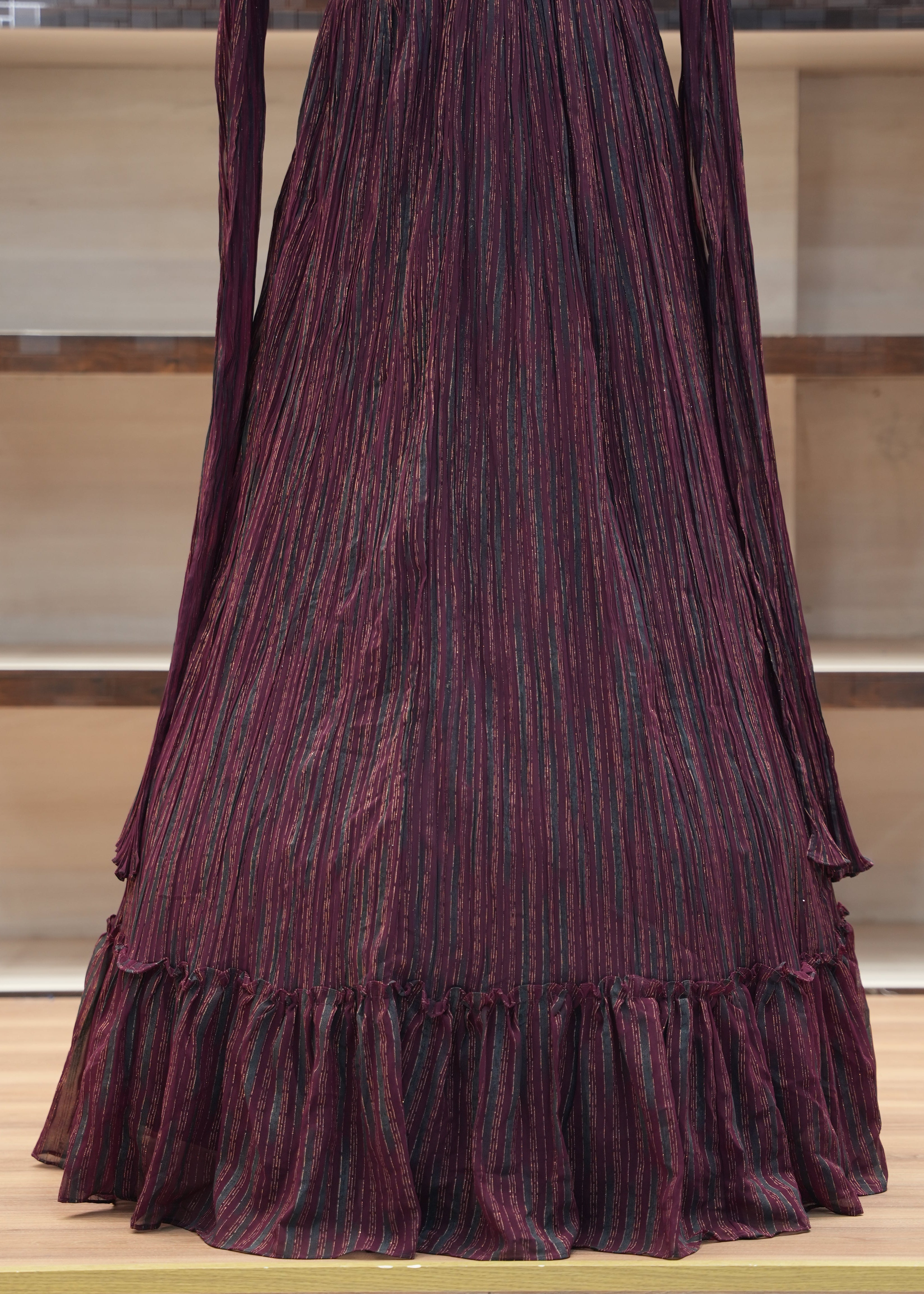 Purple pleated fabric on a wooden shelf with a neutral background