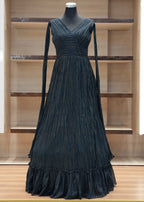 Black evening gown on a mannequin against a wooden panel background