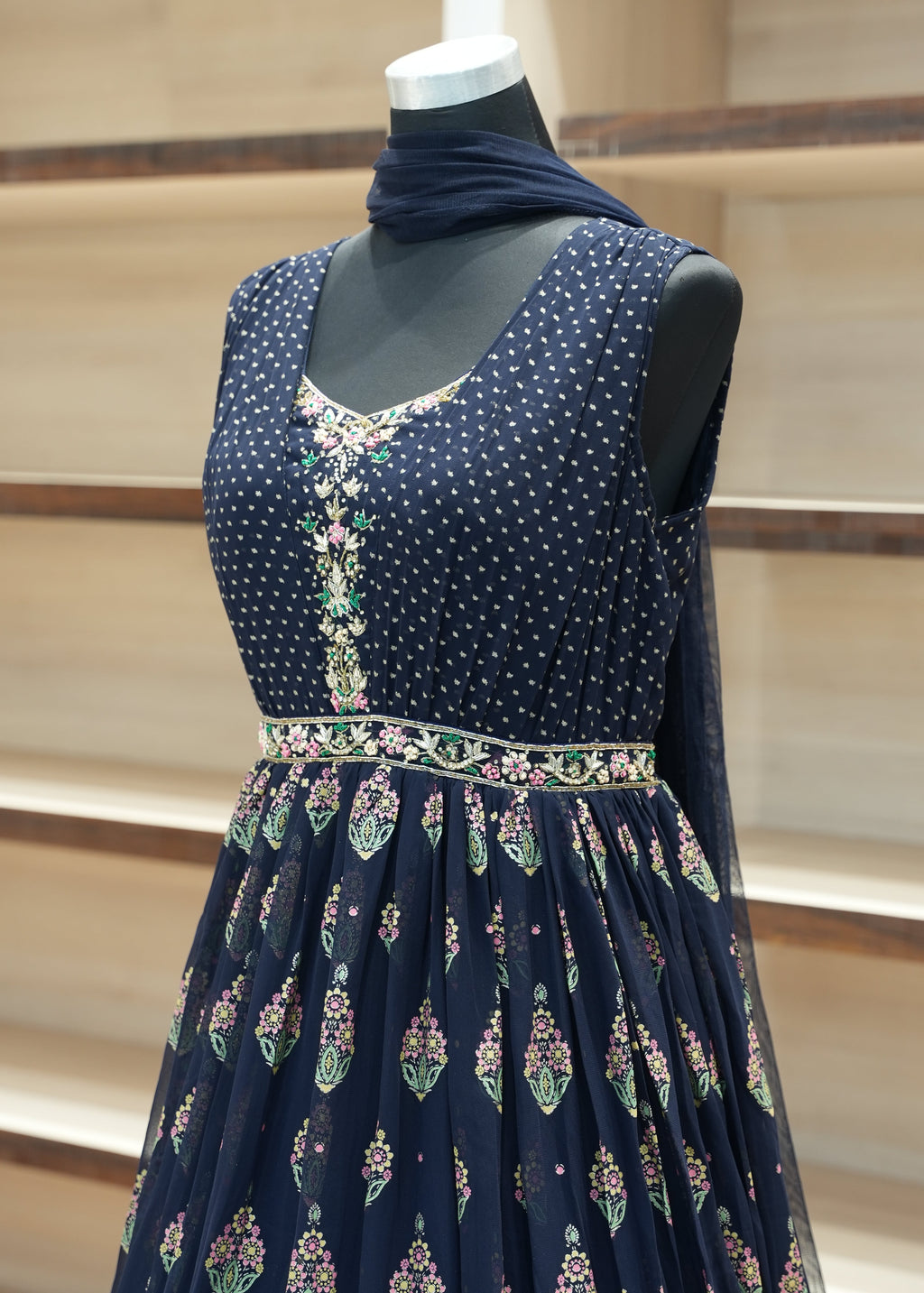 Navy blue dress with floral patterns on a mannequin against a neutral background