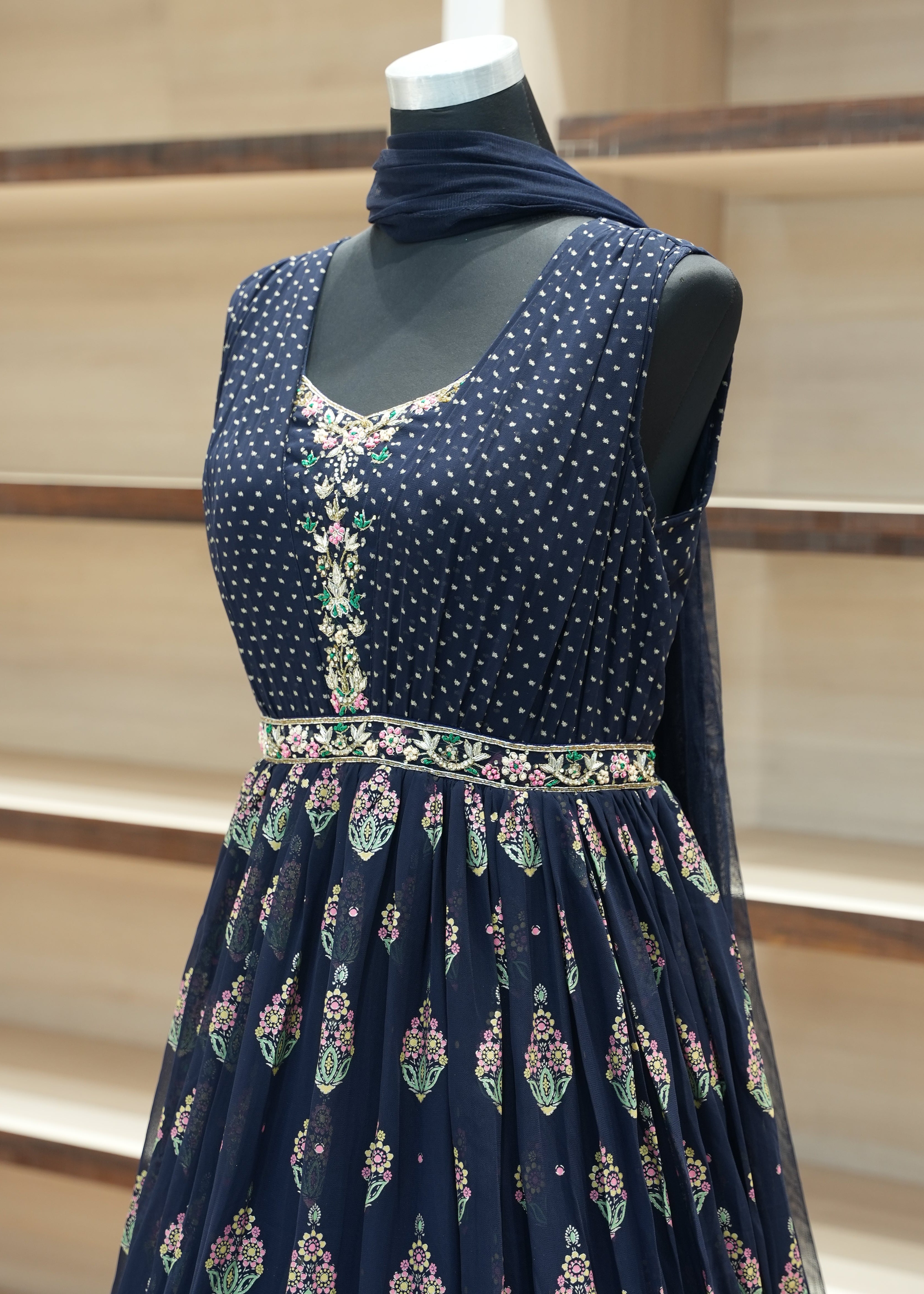 Navy blue dress with floral patterns on a mannequin against a neutral background