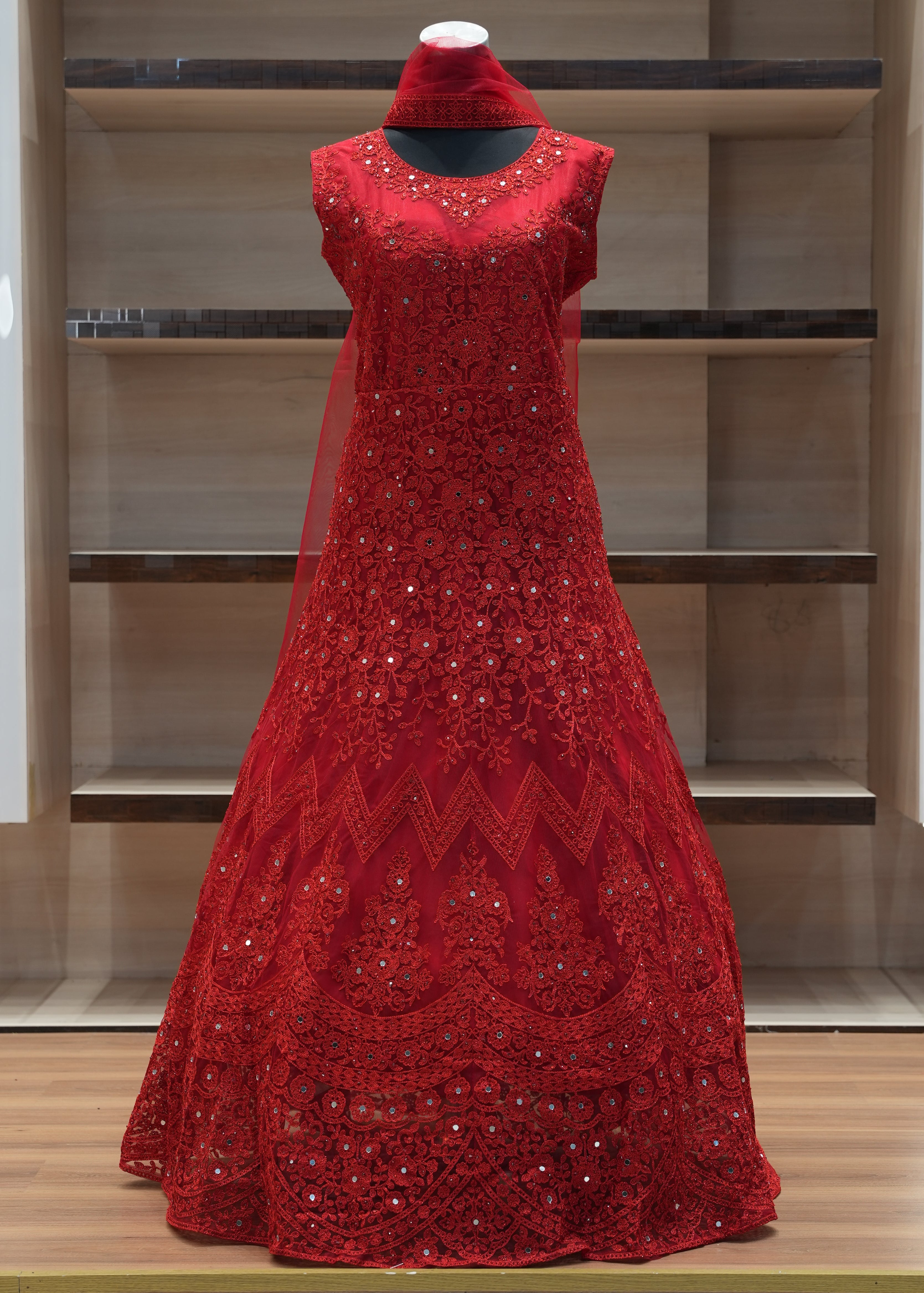 Red sequined dress on a mannequin against a wooden panel background