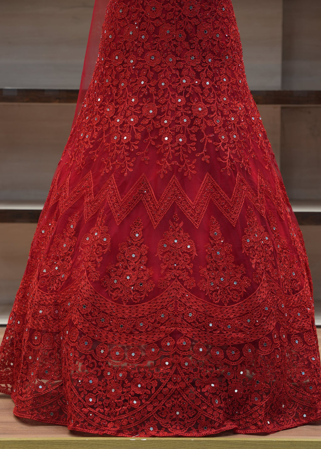 Red embroidered fabric draped over a chair with a blurred background