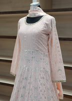 Pink embroidered traditional outfit on a mannequin against a neutral background