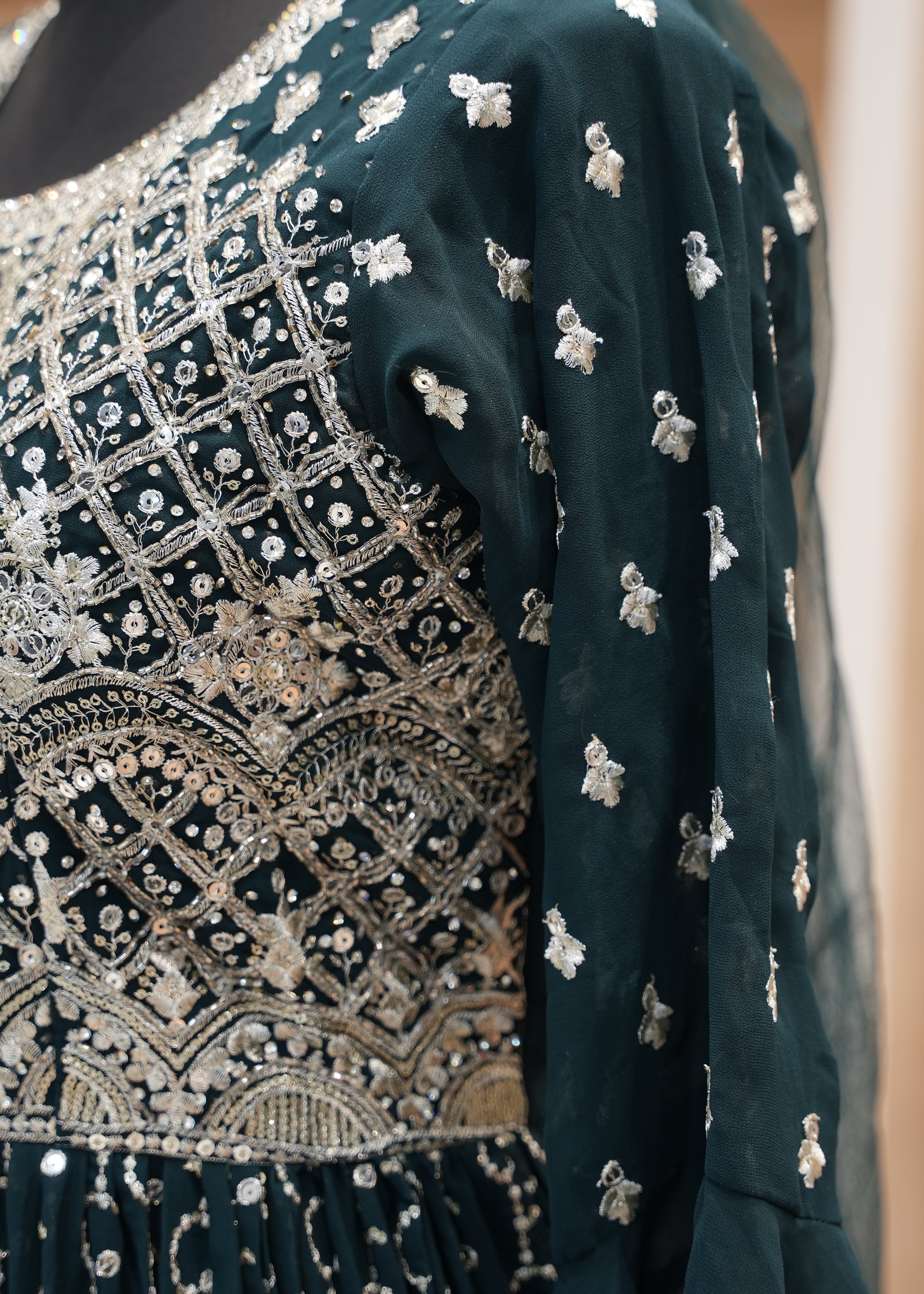 Decorative pillow with intricate silver embroidery on a dark fabric background