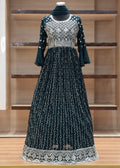 Dark blue dress with white lace details on a wooden rack.