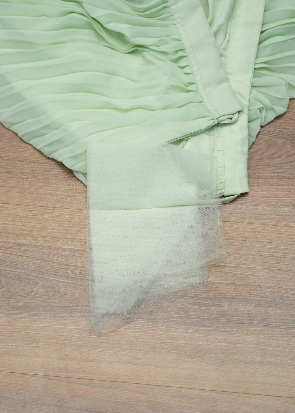 Light green fabric with ruffled edge on a wooden surface