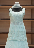 Light blue embroidered dress on a mannequin against a wooden shelf background