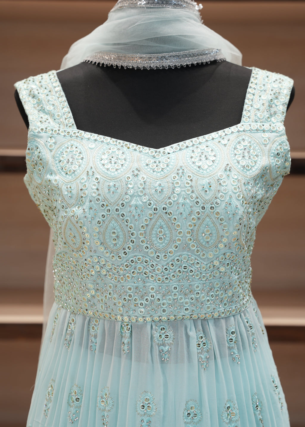 Light blue embroidered dress on a mannequin with a blurred background
