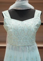 Light blue embroidered dress on a mannequin with a blurred background