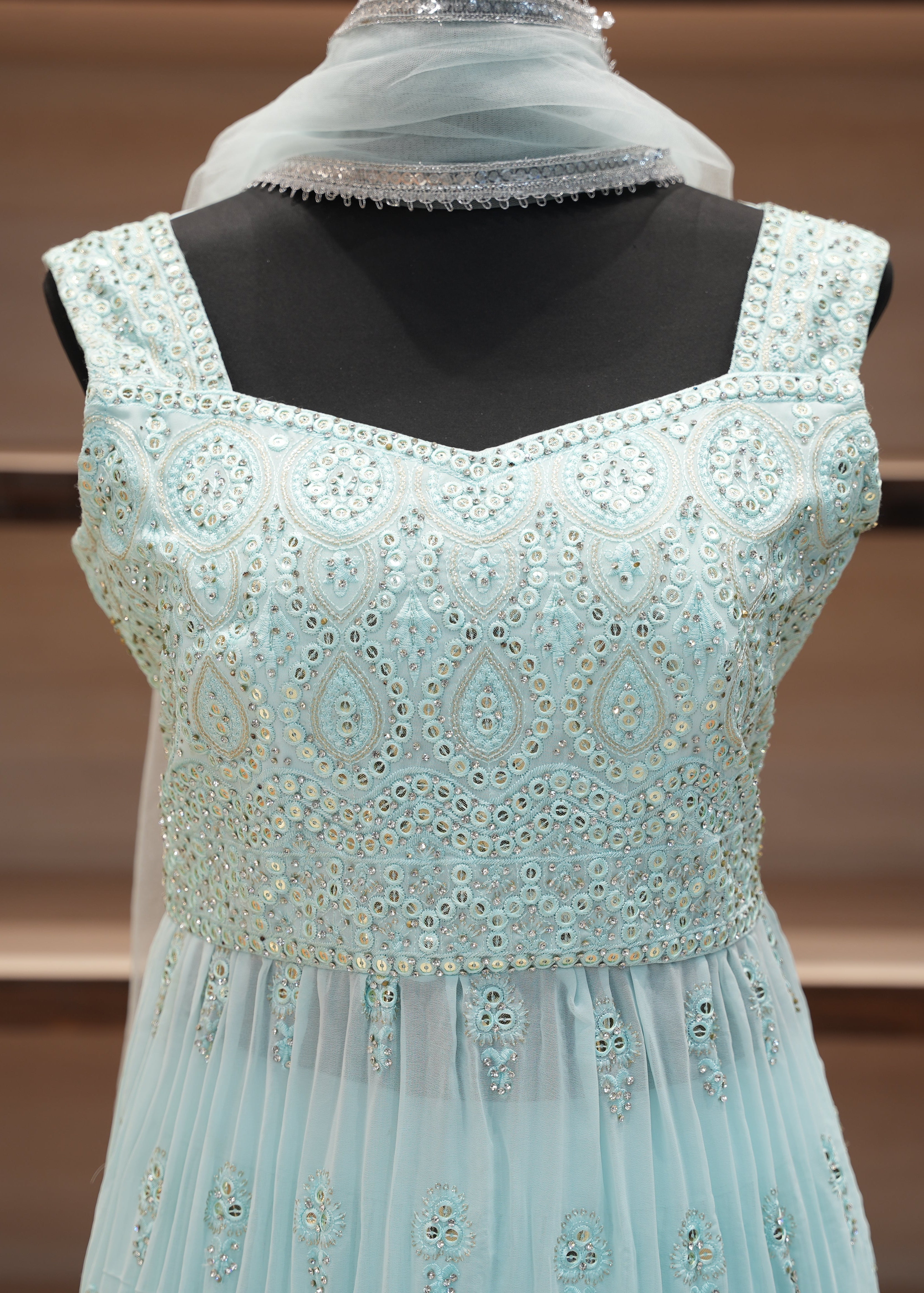 Light blue embroidered dress on a mannequin with a blurred background