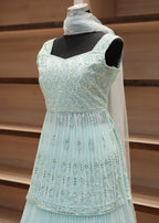 Light blue dress with black accents on a wooden surface