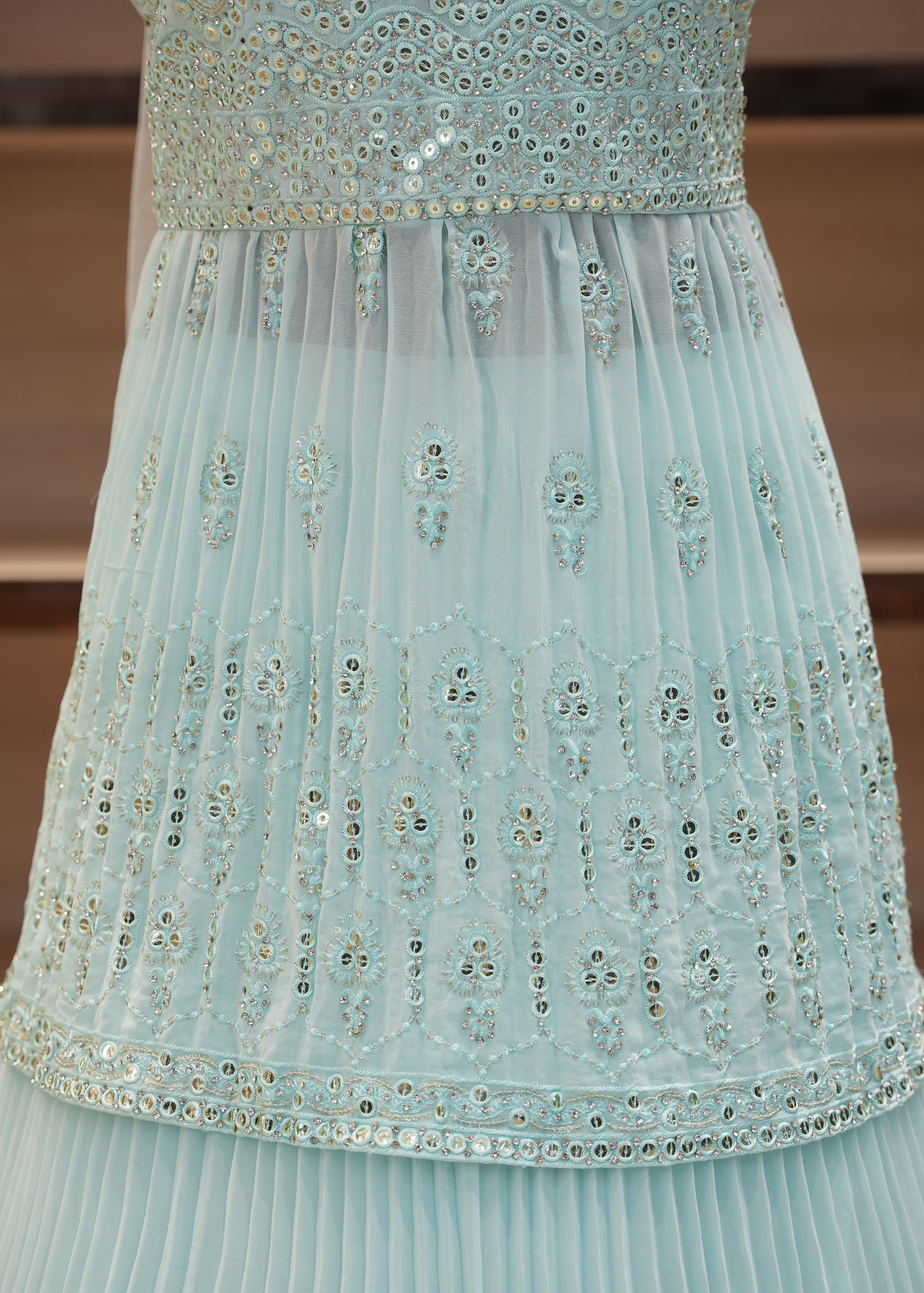 Light blue dress with floral embroidery on a wooden shelf background