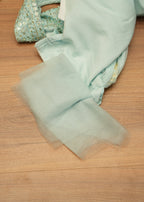 Light blue fabric with tulle on a wooden surface