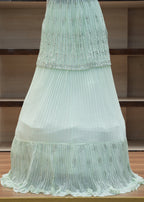 Light green pleated fabric draped over a wooden chair.