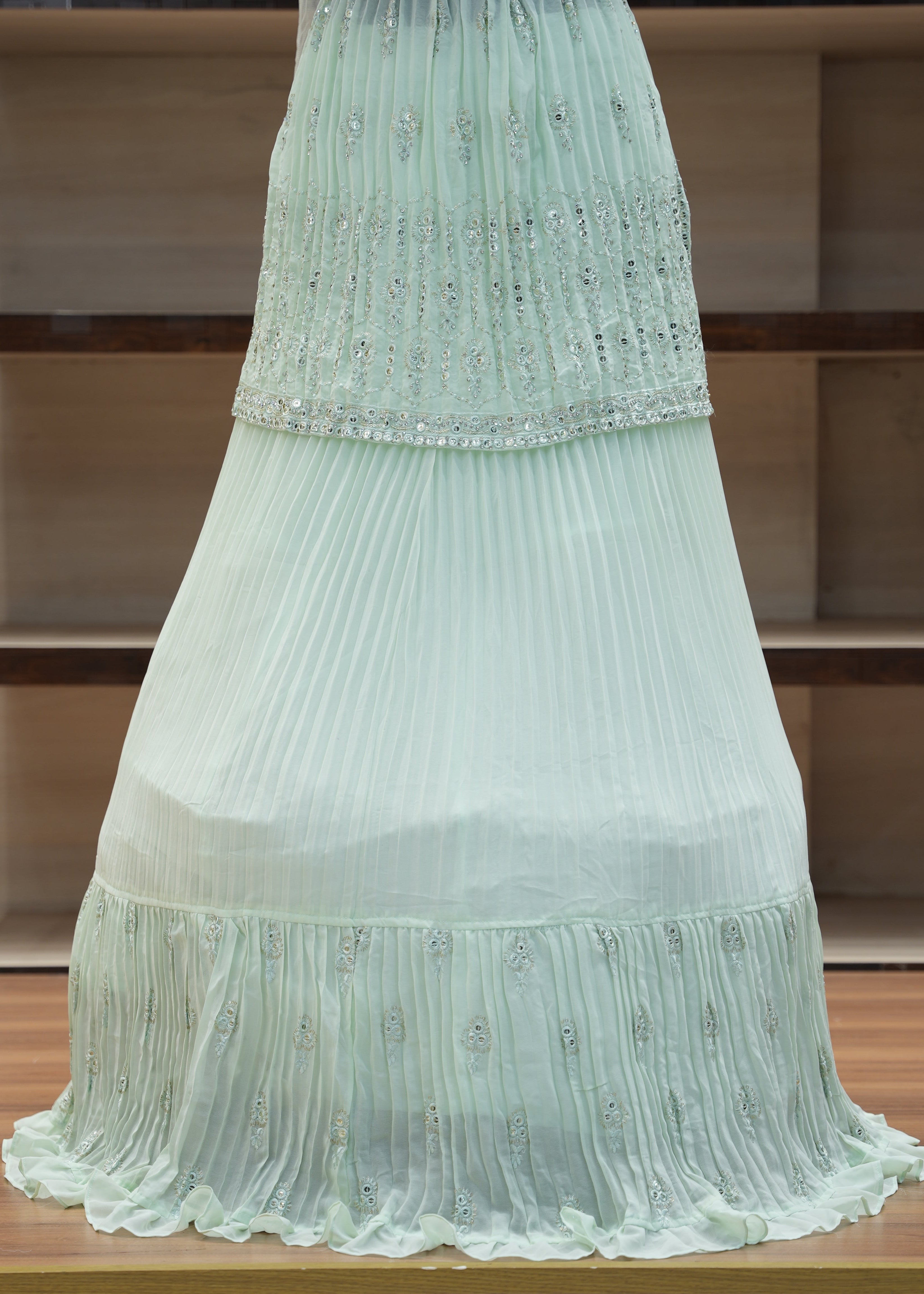 Light green pleated fabric draped over a wooden chair.