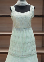 Light blue dress with decorative elements on a mannequin against a wooden panel background