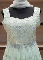 Light blue evening gown with intricate detailing on a mannequin against a blurred background