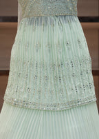 Light green pleated fabric with decorative edge on a blurred background