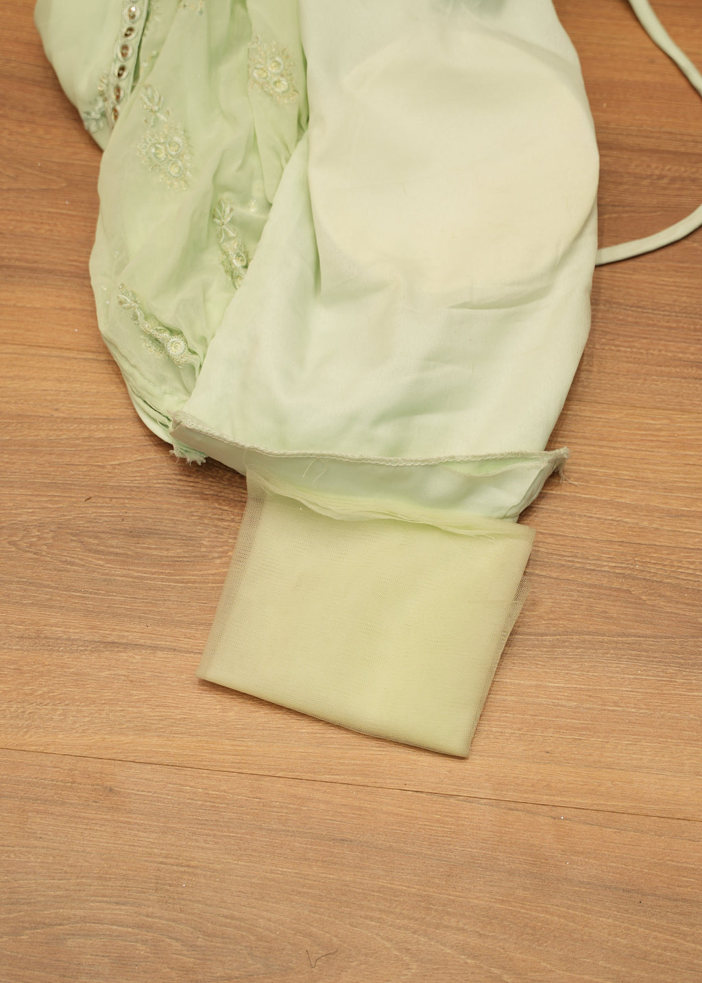 Light green fabric with a strap on a wooden surface