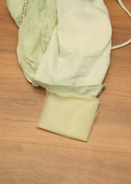 Light green fabric with a strap on a wooden surface