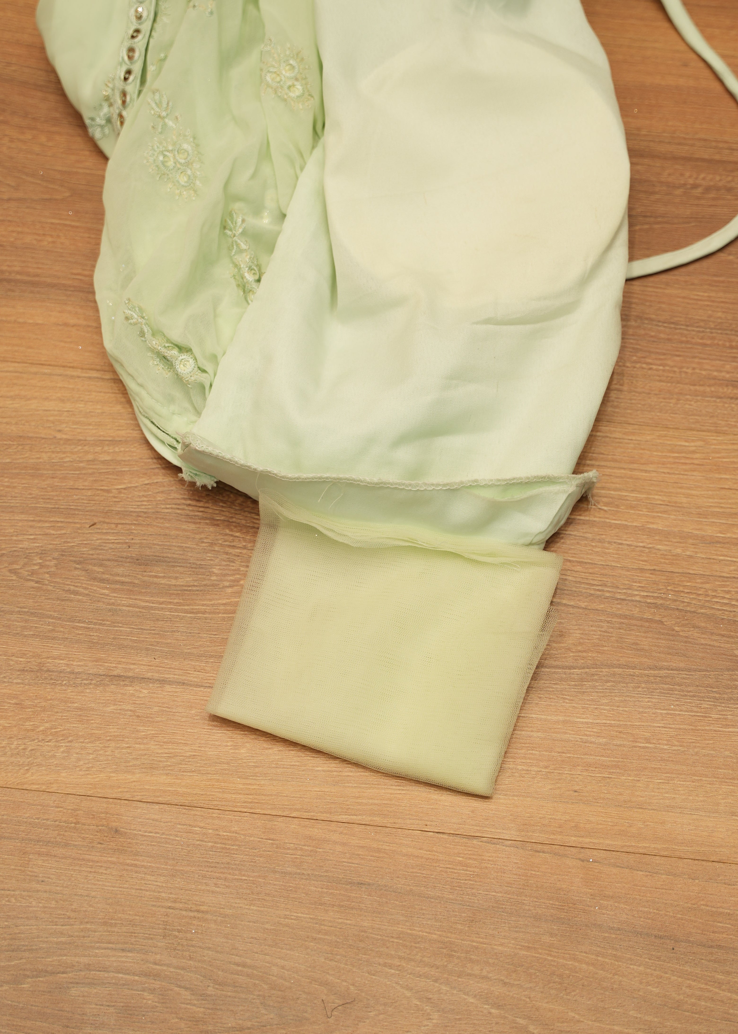 Light green fabric with a strap on a wooden surface