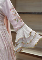 Pink embroidered fabric with floral patterns on a wooden surface