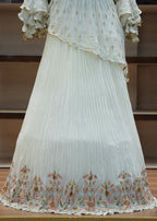 White pleated fabric with floral lace trim draped over a chair.