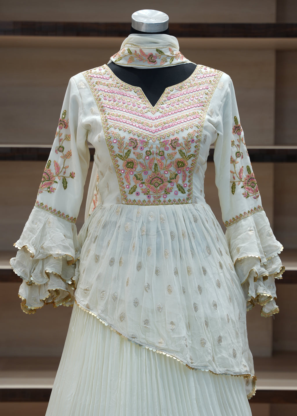 Traditional embroidered dress on a mannequin against a wooden background